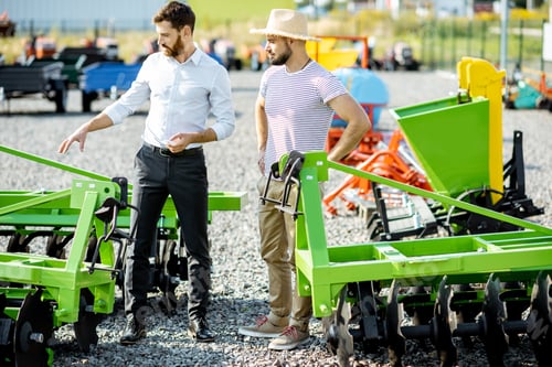 Preview: Agronomist with salesman at the shop with agricultural machinery