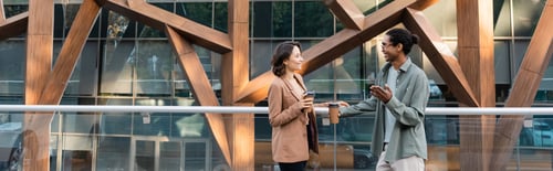Preview: trendy african american man pointing with hand while talking to woman outdoors, banner