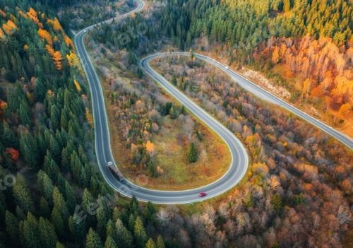 Preview: Aerial view of winding road in autumn forest at sunset