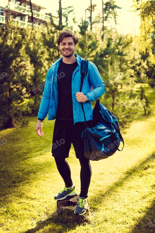 Preview: A man in a blue sports jacket with sports bag.
