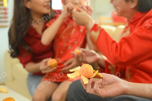 Preview: Close up of hands sharing peeled oranges together as a symbol of prosperity