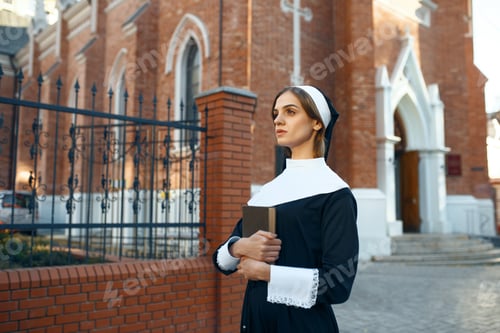 Preview: Young nun in a cassock, church on background