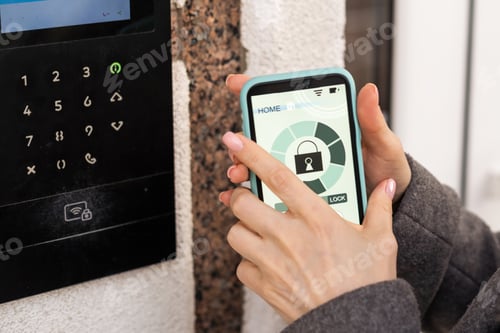 Preview: Young stylish woman getting access to the building by attaching smartphone to intercom. Concept of