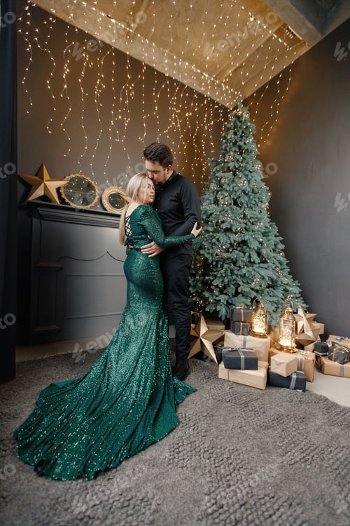 Preview: Romantic couple standing near Christmas tree wearing magnificent clothes