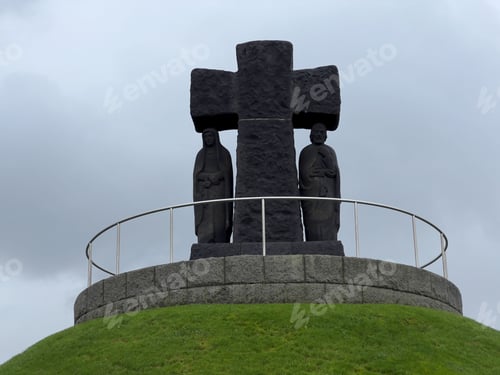 Preview: Monument with cross and statues on grassy hill