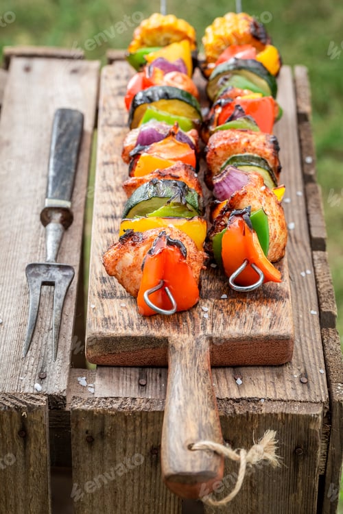 Preview: Healthy grilled skewers served with water in summer