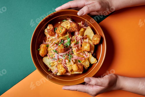 Preview: a bowl filled with potatoes, ham and gravy on top of an orange