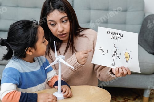 Preview: Asian mother working with her child on renewable energy project for school science class at home