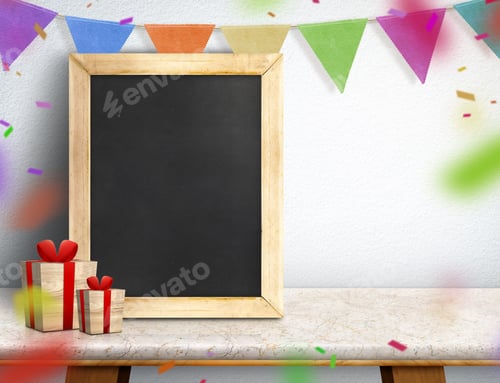 Preview: Blackboard with gift box and colorful flag banner on marble table at white wall