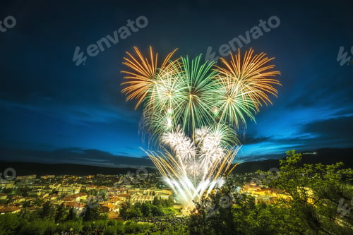 Preview: Fireworks above the city covered in buildings and greenery during the night