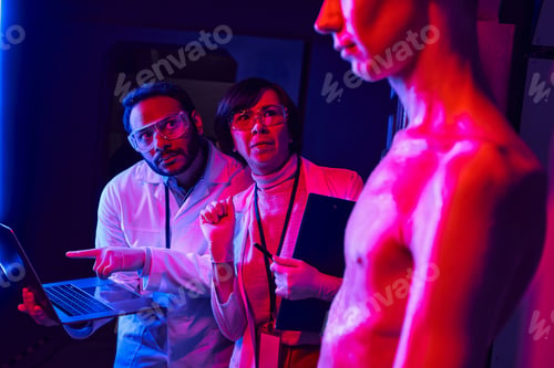 Preview: unknown cosmic creature near multiethnic scientists with laptop in futuristic laboratory