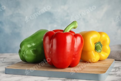 Preview: Wooden board with ripe paprika peppers on table