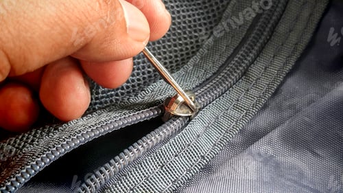 Preview: Person's Hand Aligning a Zipper on a Backpack