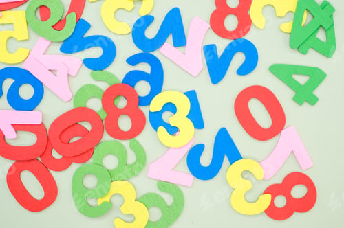 Preview: Top view of the colorful wooden numbers scattered on a green surface