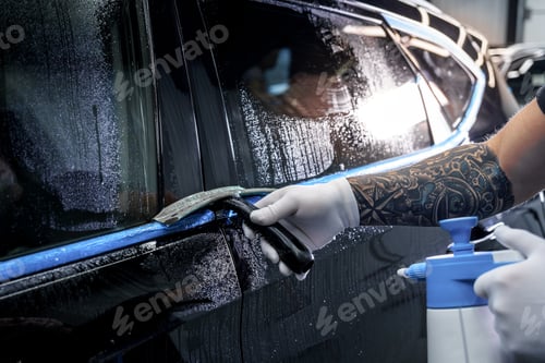 Preview: Sticker of a protective film on the headlight of a car in a car detailing studio