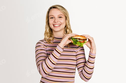 Preview: Happy woman eating a hamburger for lunch