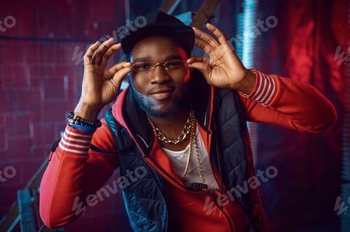 Preview: Rapper in stylish gold glasses posing in studio