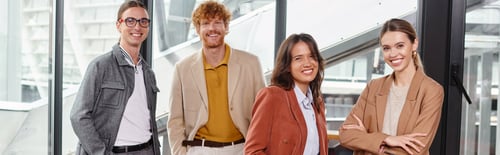 Preview: creative cheerful team members in smart casual outfits posing with glass backdrop, coworking, banner