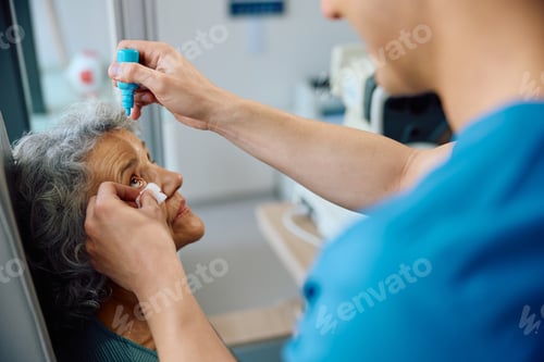 Preview: Senior woman having pupil dilation during eyesight exam at ophthalmologist.