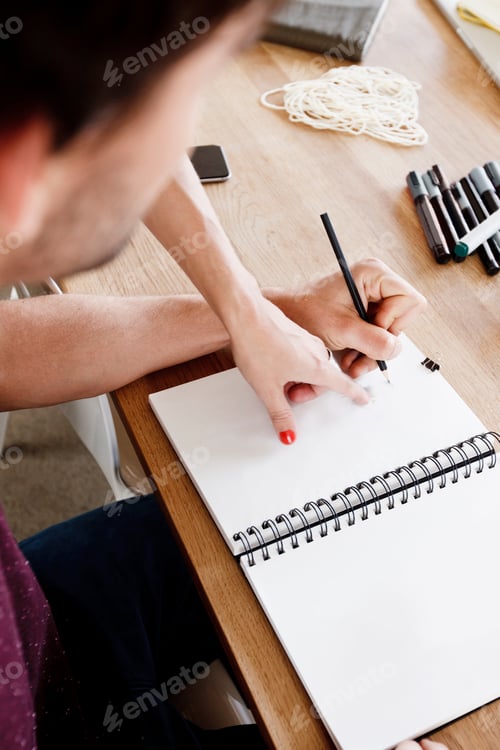 Preview: Cropped view of colleagues sketching fashion design