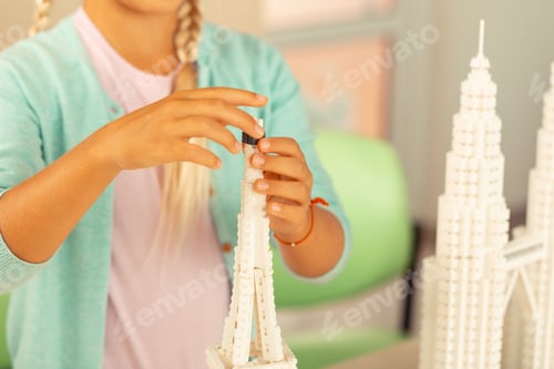 Preview: Schoolgirl putting the finishing touches to her building
