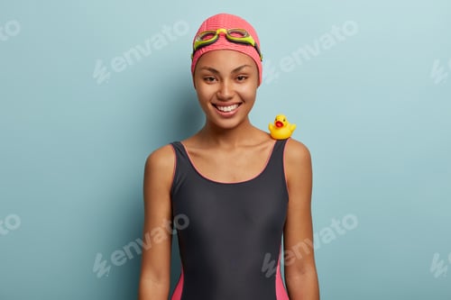 Preview: Horizontal shot of glad female traveler spends summer vacation actively, enjoys swimming in water, w