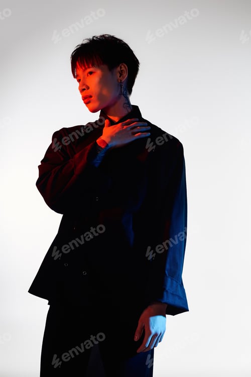 Preview: Stylish young asian man showcasing modern fashion against a vibrant backdrop of bold colors