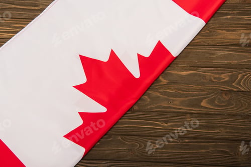 Preview: top view of canadian flag with maple leaf on wooden surface