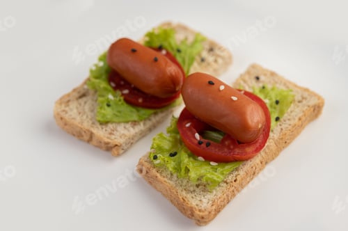 Preview: Sausage with tomatoes, salad and two sets of bread on a white plate.