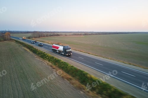 Preview: Aerial view of blurred fast moving fuel cargo truck driving on highway hauling goods.