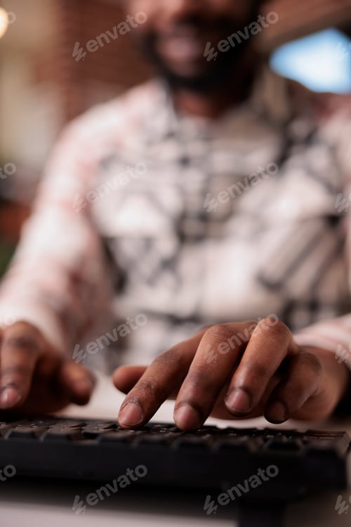 Preview: Closeup of african american coder writing software using computer keyboard while working remote