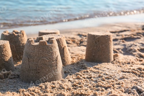 Preview: View of beach with little sand figures near sea on sunny summer day. Space for text