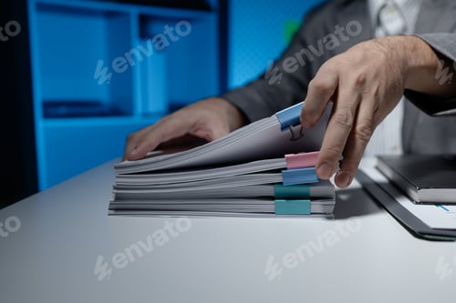 Preview: An employee held a large pile of documents in his hand, Large piles of work documents on desks are b