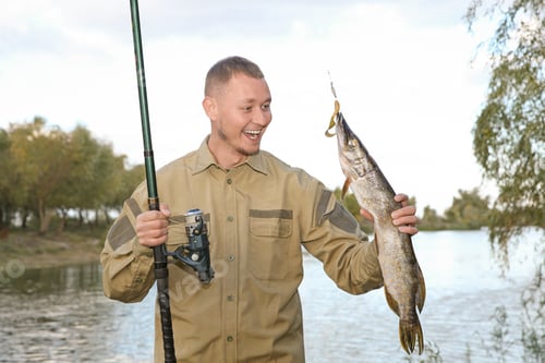 Preview: Man with rod and catch fishing at riverside. Recreational activity