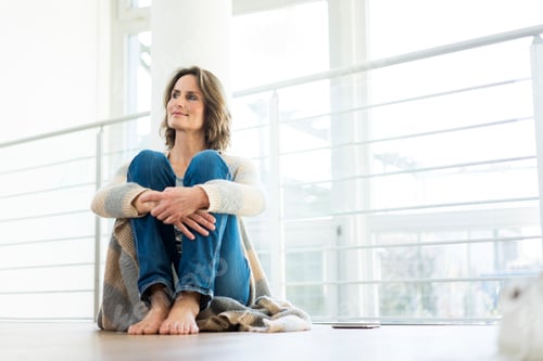 Preview: Relaxed woman sitting on the floor at home