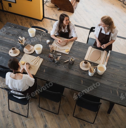 Preview: Caucasian female best friends pottery artists decorating a ceramic pod, talking and smiling during