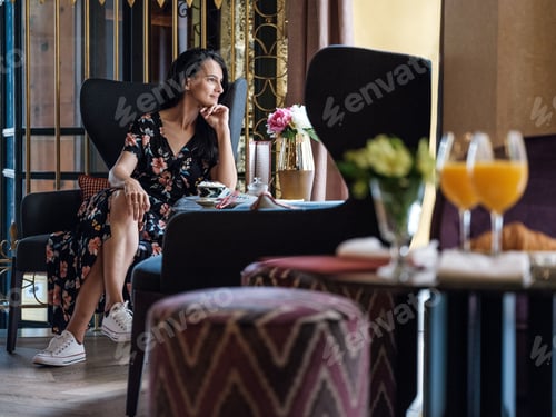 Preview: Woman having breakfast in luxury room