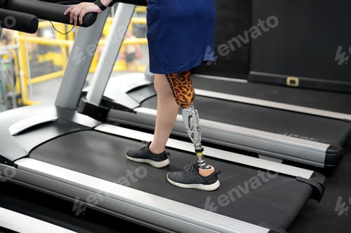Preview: woman with prosthetic leg at fitness gym.