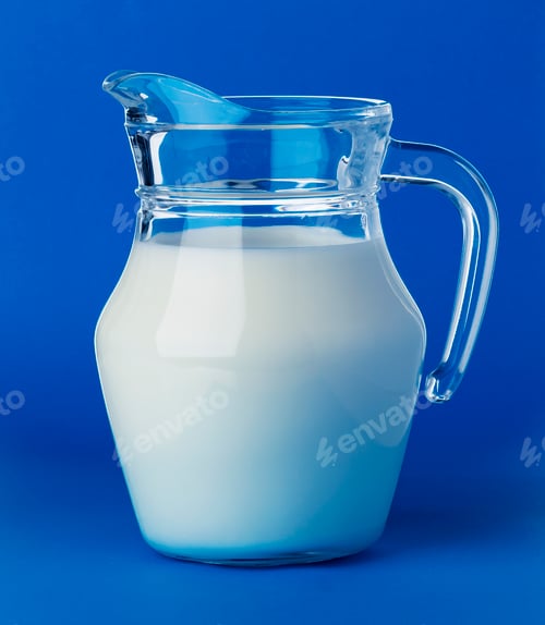Preview: Glass jug of milk isolated on blue background