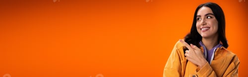 Preview: Positive young woman pointing with finger isolated on orange with copy space, banner