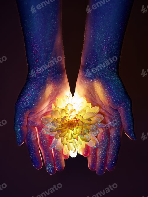Preview: Beauty hands of a woman in ultraviolet light with flowers in the palms. Cosmetics for hand skin care