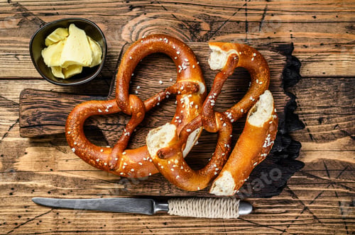 Preview: Baked pretzels with sea salt on a rustic wooden cutting board. Wooden background. Top view