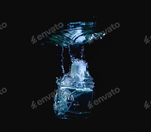 Preview: Bottle of perfume drowning in water