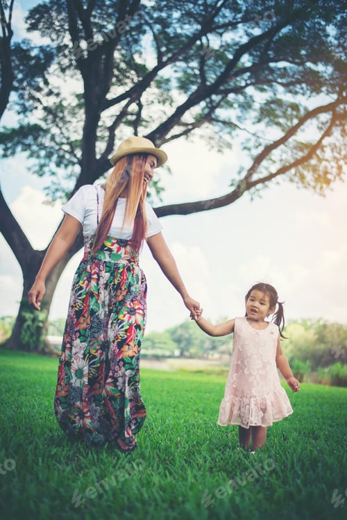 Preview: Young mother and her little daughter walking in ther park