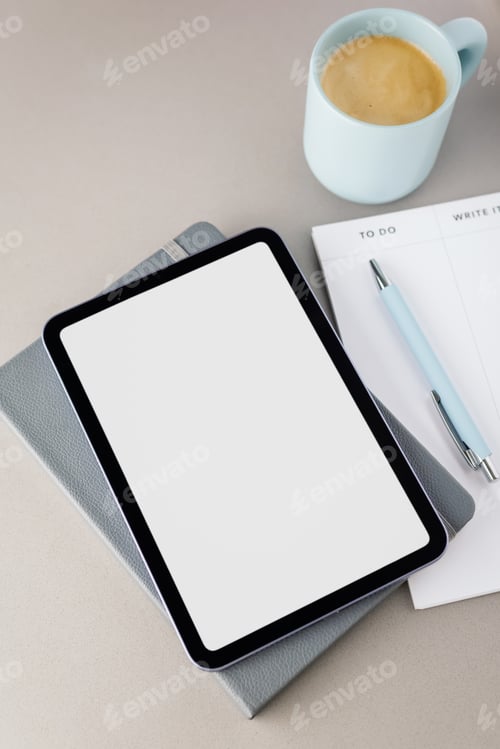 Preview: Top view of a digital tablet with a white screen, a pen, a notepad and a cup of fresh coffee. Do it.