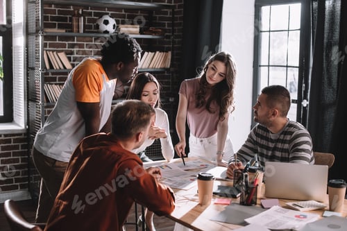 Preview: young multicultural businesspeople discussing business ideas near desk in office