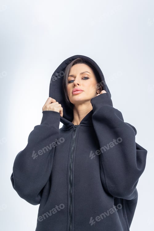 Preview: Portrait beautiful woman of model appearance. Girl in black sweatshirt on grey background. Pretty