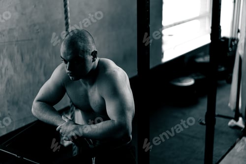 Preview: in the gym bald trainer stands near the horizontal bar for push-ups and pull-ups