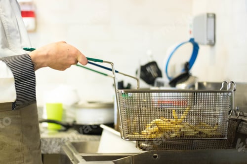 Preview: Cook preparing french fries in the kitchen