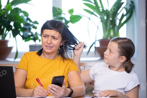 Preview: Mother working from home with kid. Children make noise and disturb woman at work.